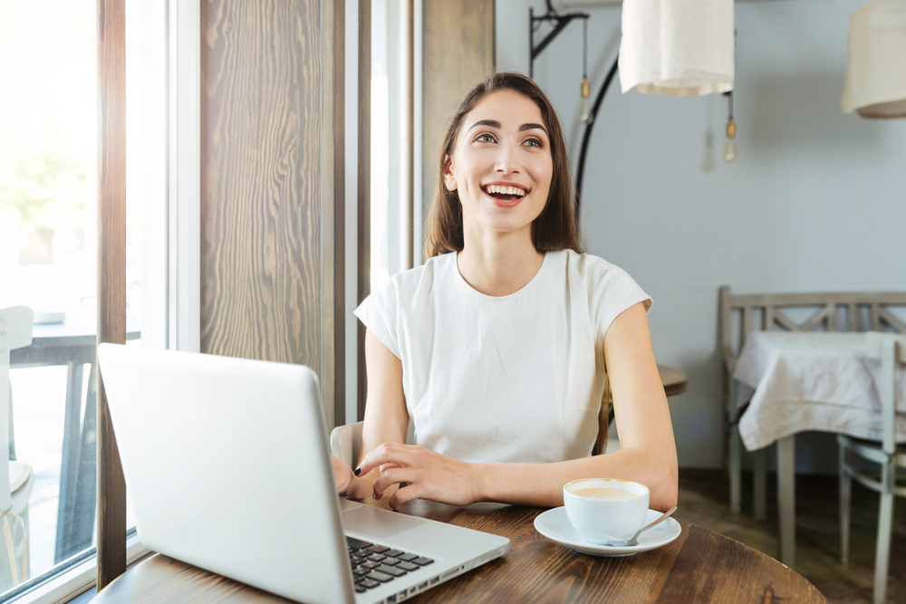 Lachende vrouw achter laptop
